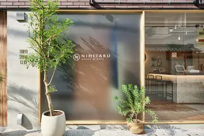 a store window with two potted trees in front of it at NiHITARU Stay in Tokyo
