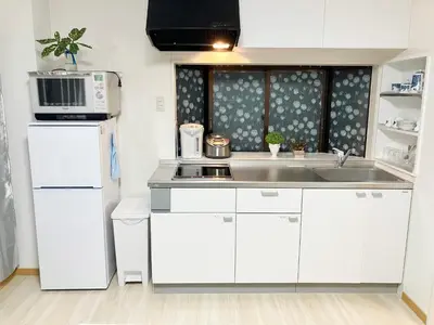a white kitchen with a sink and a microwave at Ueno Yuyuhouse 1LDK for rent, Close to Senso-ji Temple,Kaminarimon Gate,Kappabashi Dougu Street,Akihabara,Shinjuku and Disneyland in Tokyo