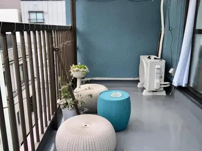 a balcony with two stools and a table on a balcony at Ueno Yuyuhouse 1LDK for rent, Close to Senso-ji Temple,Kaminarimon Gate,Kappabashi Dougu Street,Akihabara,Shinjuku and Disneyland in Tokyo