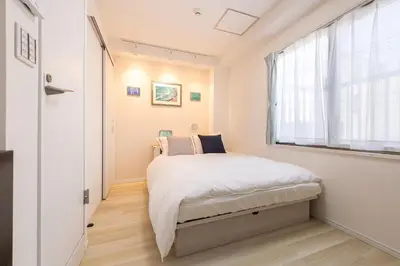 a small bedroom with a bed and a window at Peace Inn Shinjuku Tokyo in Tokyo