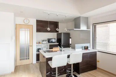 a kitchen with a counter and some chairs in it at Peace Inn Shinjuku Tokyo in Tokyo