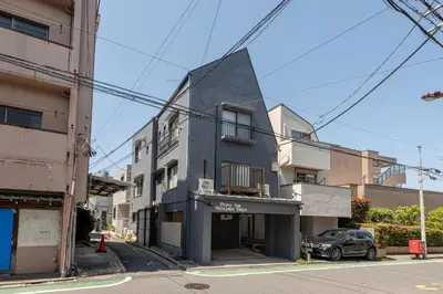 a building with a black facade on a street at Peace Inn Shinjuku Tokyo in Tokyo