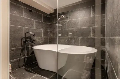 a bathroom with a bath tub and a shower at Peace Inn Shinjuku Tokyo in Tokyo