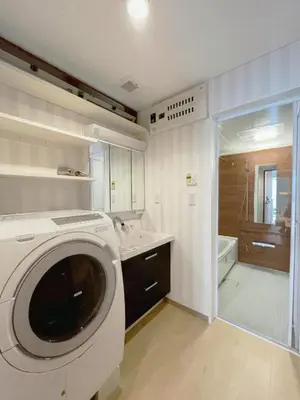 a washing machine in a bathroom with a shower at WE Hotel Family House in Tokyo
