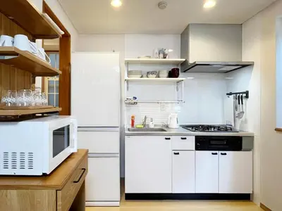 a kitchen with white appliances and a microwave at WE Hotel Family House in Tokyo