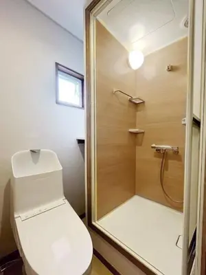 a bathroom with a toilet and a glass shower at WE Hotel Family House in Tokyo