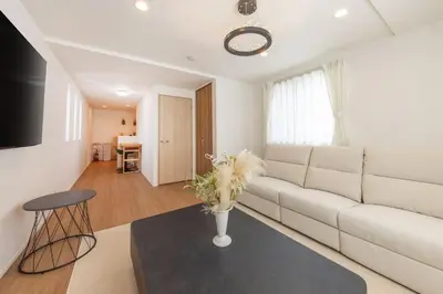 a living room with a white couch and a table at \u6771\u4eac\u65b0\u7bc985\u5e73\u7c73\u99c5\u5f92\u6b696\u5206\u6700\u59278\u540d\u7121\u6599\u99d0\u8eca\u5834\u6771\u4eac\u4e0a\u91ce\u79cb\u8449\u539f\u99c5\u76f4\u901a in Tokyo