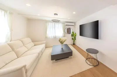 a living room with a white couch and a table at \u6771\u4eac\u65b0\u7bc985\u5e73\u7c73\u99c5\u5f92\u6b696\u5206\u6700\u59278\u540d\u7121\u6599\u99d0\u8eca\u5834\u6771\u4eac\u4e0a\u91ce\u79cb\u8449\u539f\u99c5\u76f4\u901a in Tokyo