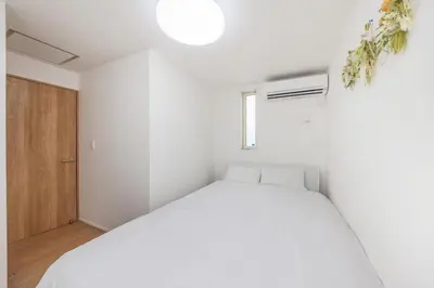 a white bedroom with a bed and a window at \u6771\u4eac\u65b0\u7bc985\u5e73\u7c73\u99c5\u5f92\u6b696\u5206\u6700\u59278\u540d\u7121\u6599\u99d0\u8eca\u5834\u6771\u4eac\u4e0a\u91ce\u79cb\u8449\u539f\u99c5\u76f4\u901a in Tokyo