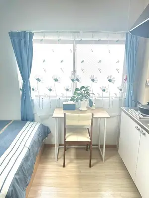a bedroom with a table and a window with flowers on it at Ueno Yuyuhouse 1Room for rent, Close to Senso-ji Temple,Kaminarimon Gate,Kappabashi Dougu Street,Akihabara,Shinjuku and Disneyland in Tokyo