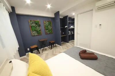 a bedroom with a white bed and a blue wall at Shibuya WAVE 301 in Tokyo