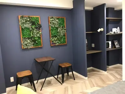 a room with two stools and a green wall at Shibuya WAVE 301 in Tokyo