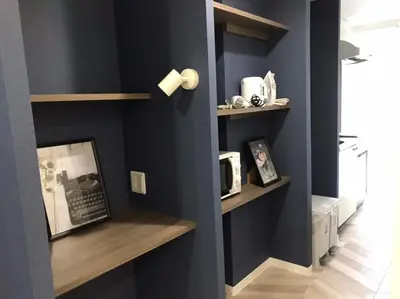 a room with a blue wall with shelves and a microwave at Shibuya WAVE 301 in Tokyo