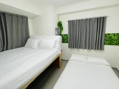 two beds in a room with two windows at GLOU Shinjuku Family - Urban Stay in Tokyo Shinjuku Area, Walking distance of Kabukicho in Tokyo