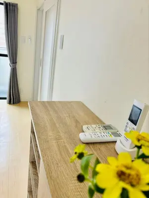 a table with a remote control and a phone on it at GLOU Shinjuku Family - Urban Stay in Tokyo Shinjuku Area, Walking distance of Kabukicho in Tokyo