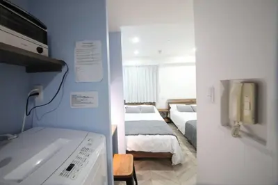 a room with two beds and a sink in it at Shibuya WAVE 302 in Tokyo