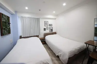 two beds in a room with white walls at Shibuya WAVE 302 in Tokyo