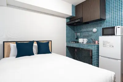 a small bedroom with a bed and a refrigerator at \u30ec\u30ea\u30aa\u30f3\u4e0b\u843d\u5408 in Tokyo