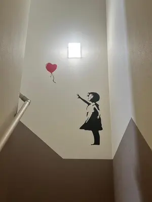 a wall stencil of a woman with a balloon at \u30a2\u30fc\u30c8\u30cf\u30a6\u30b9 in Tokyo