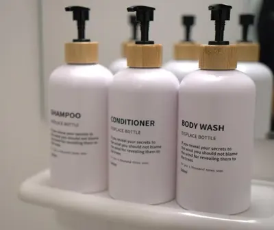 four white bottles of laundry detergent sitting on a shelf at \u30a2\u30fc\u30c8\u30cf\u30a6\u30b9 in Tokyo