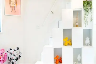 a white staircase with pictures on the wall at \u30a2\u30fc\u30c8\u30cf\u30a6\u30b9 in Tokyo
