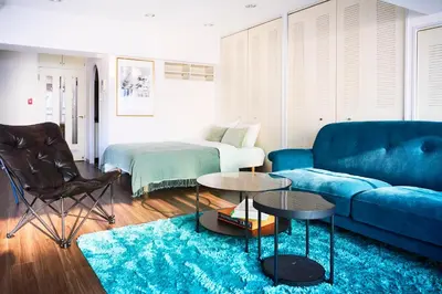 a living room with a blue couch and a blue rug at Central Shinjuku apartment with beautiful city view 3stops to Shibuya in Tokyo