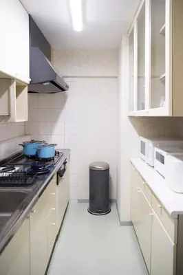 a kitchen with white cabinets and blue pots on the stove at Central Shinjuku apartment with beautiful city view 3stops to Shibuya in Tokyo