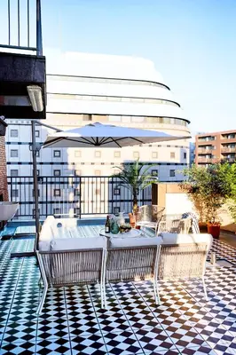 a table and chairs on a balcony with an umbrella at Central Shinjuku apartment with beautiful city view 3stops to Shibuya in Tokyo
