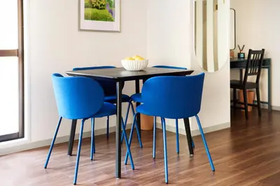 a table with blue chairs in a room at Central Shinjuku apartment with beautiful city view 3stops to Shibuya in Tokyo