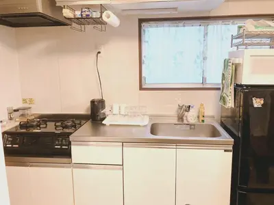 a kitchen with a sink and a stove at SKY BLUE HOUSE Asakusabashi in Tokyo
