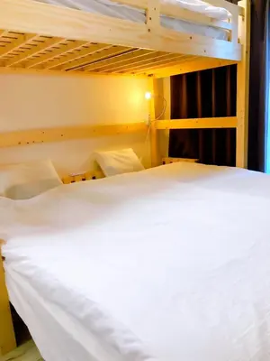 a bedroom with two bunk beds with white sheets at SKY BLUE HOUSE Asakusabashi in Tokyo