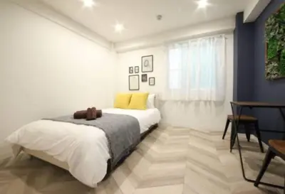 a white bedroom with a bed and a table at Shibuya WAVE 402 in Tokyo