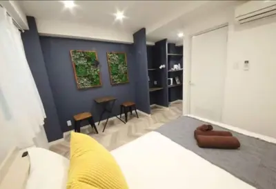 a bedroom with a white bed and a blue wall at Shibuya WAVE 402 in Tokyo
