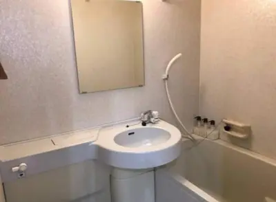 a white bathroom with a sink and a mirror at Shibuya WAVE 402 in Tokyo