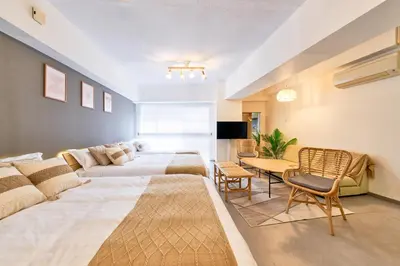 a bedroom with two beds and a couch and a table at Shinjuku Waseda Stay in Tokyo