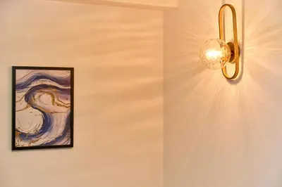 a light fixture hanging on a wall with a painting at Shinjuku Waseda Stay in Tokyo