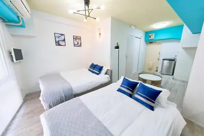 a bedroom with two beds and a tv in it at Shinjuku Waseda Stay in Tokyo