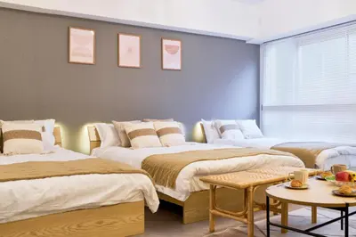 a bedroom with three beds and a table at Shinjuku Waseda Stay in Tokyo
