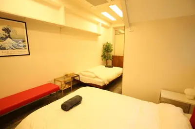 a room with two beds and a red bench at \u6771\u4eac\u30b9\u30ab\u30a4\u30c4\u30ea\u30fc\u773a\u671b \u4e00\u68df\u8cb8\u5207 \u99c5\u5f92\u6b6950\u79d2 \u6d45\u83498\u5206 \u30b9\u30ab\u30a4\u30c4\u30ea\u30fc4\u5206 \u9280\u5ea720\u5206 in Tokyo