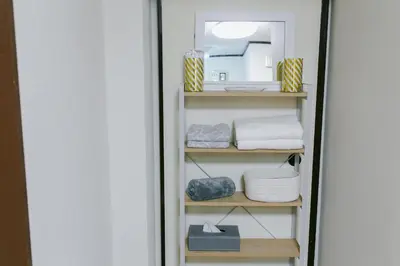 a shelf with towels and a mirror in a room at King bed house 5mins from Ikebukuro by train in Tokyo