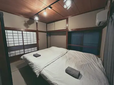 a small room with a bed and two windows at 5min to Station, Best Value 3BR Sleeps 8, Quiet Area in Tokyo