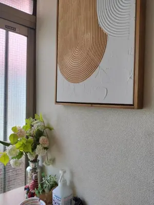 a picture on a wall with a vase of flowers on a table at JOY HOUSE Near Ikebukuro in Tokyo