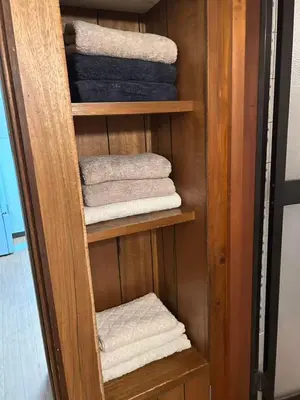 a wooden shelf with towels in a closet at JOY HOUSE Near Ikebukuro in Tokyo