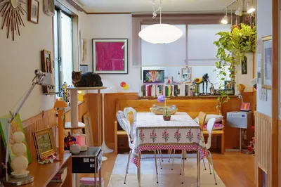 a dining room with a table and a cat in a room at Artful Cats house in Tokyo