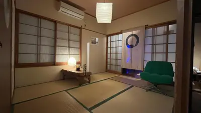 a room with a green chair and a table at Artful Cats house in Tokyo