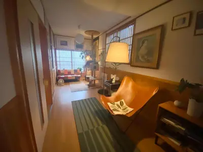 a living room with an orange chair and a couch at Artful Cats house in Tokyo