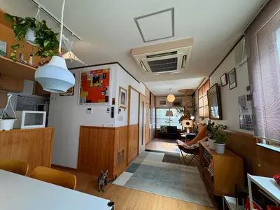 a living room with a person sitting in a chair at Artful Cats house in Tokyo