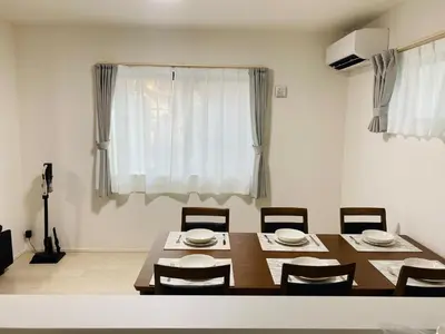 a dining room with a table and chairs and a window at Daiichi House in Tokyo