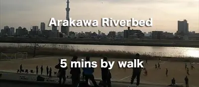 a group of people walking on a beach near a city at Daiichi House in Tokyo