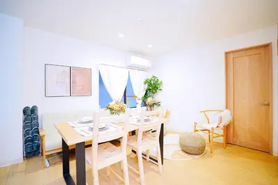 a white dining room with a table and chairs at Bohemian Tokyo in Tokyo